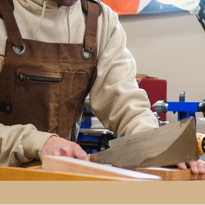Man working on a project in a workshop with a 'Newport' sign in the background