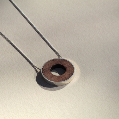 Necklace with a wooden pendant on a neutral background