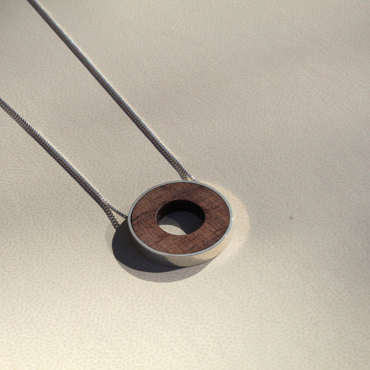 Necklace with a wooden pendant on a neutral background