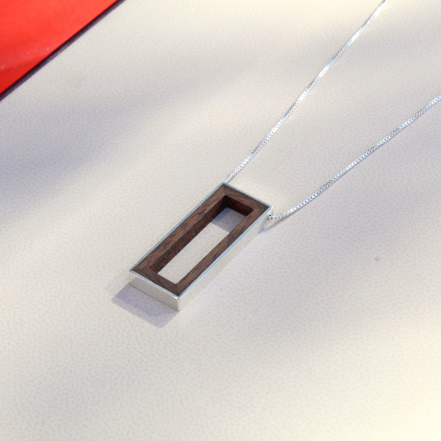 Close up of wood pendant with silver rim