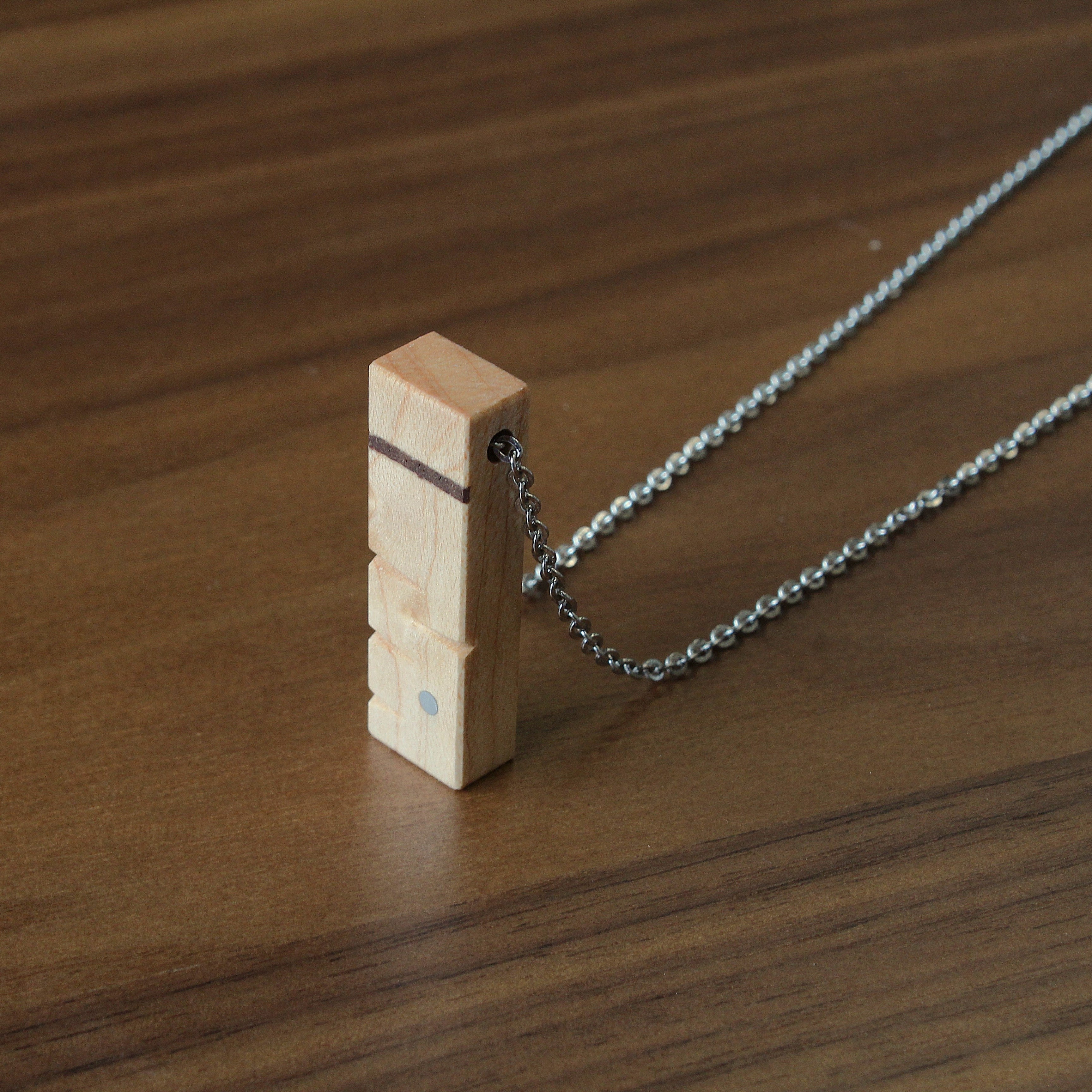 Necklace with a wooden pendant on a wooden surface