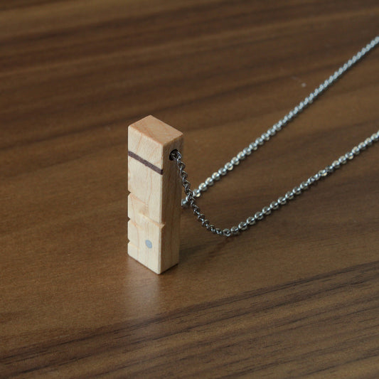 Necklace with a wooden pendant on a wooden surface