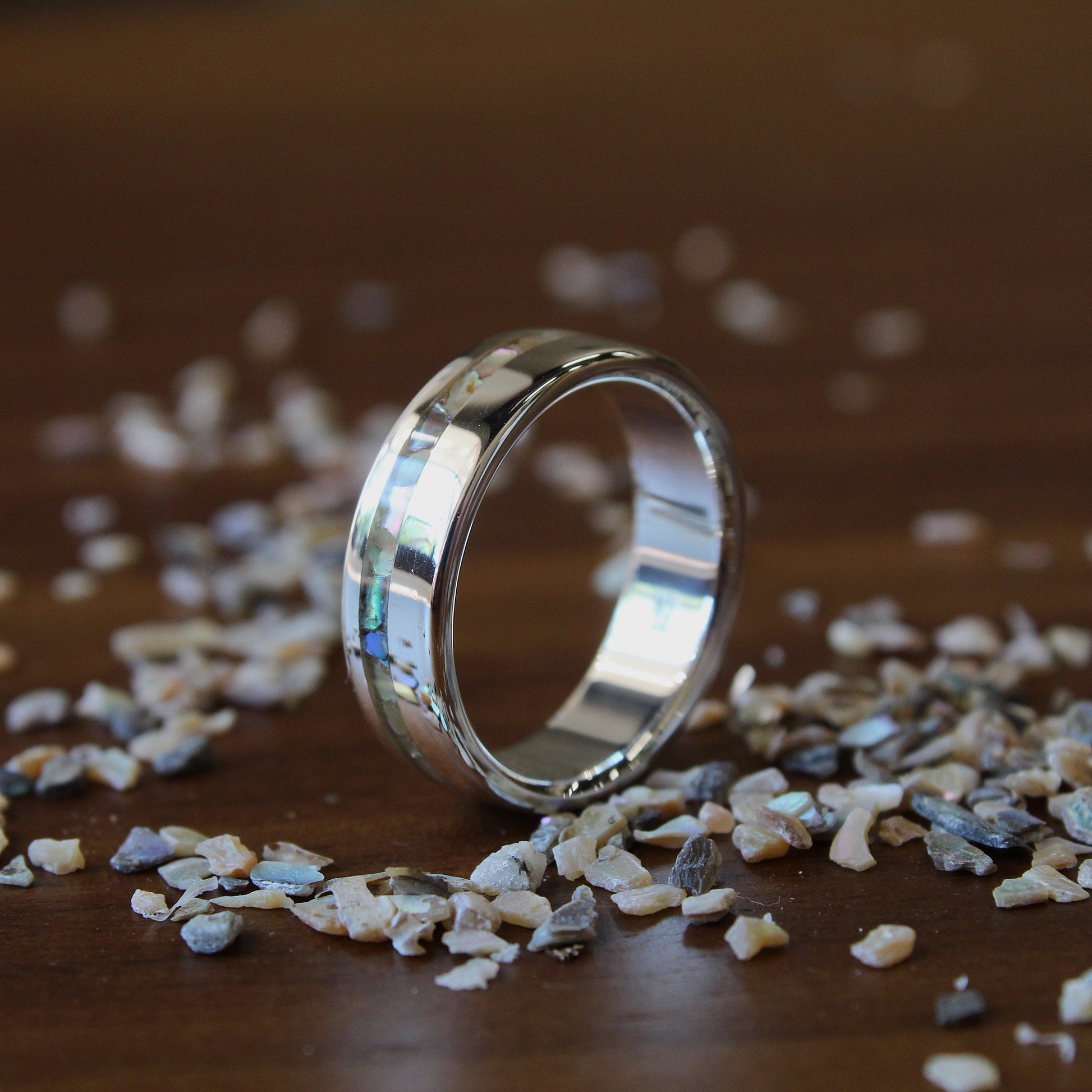 Silver ring on a wooden surface with small stones