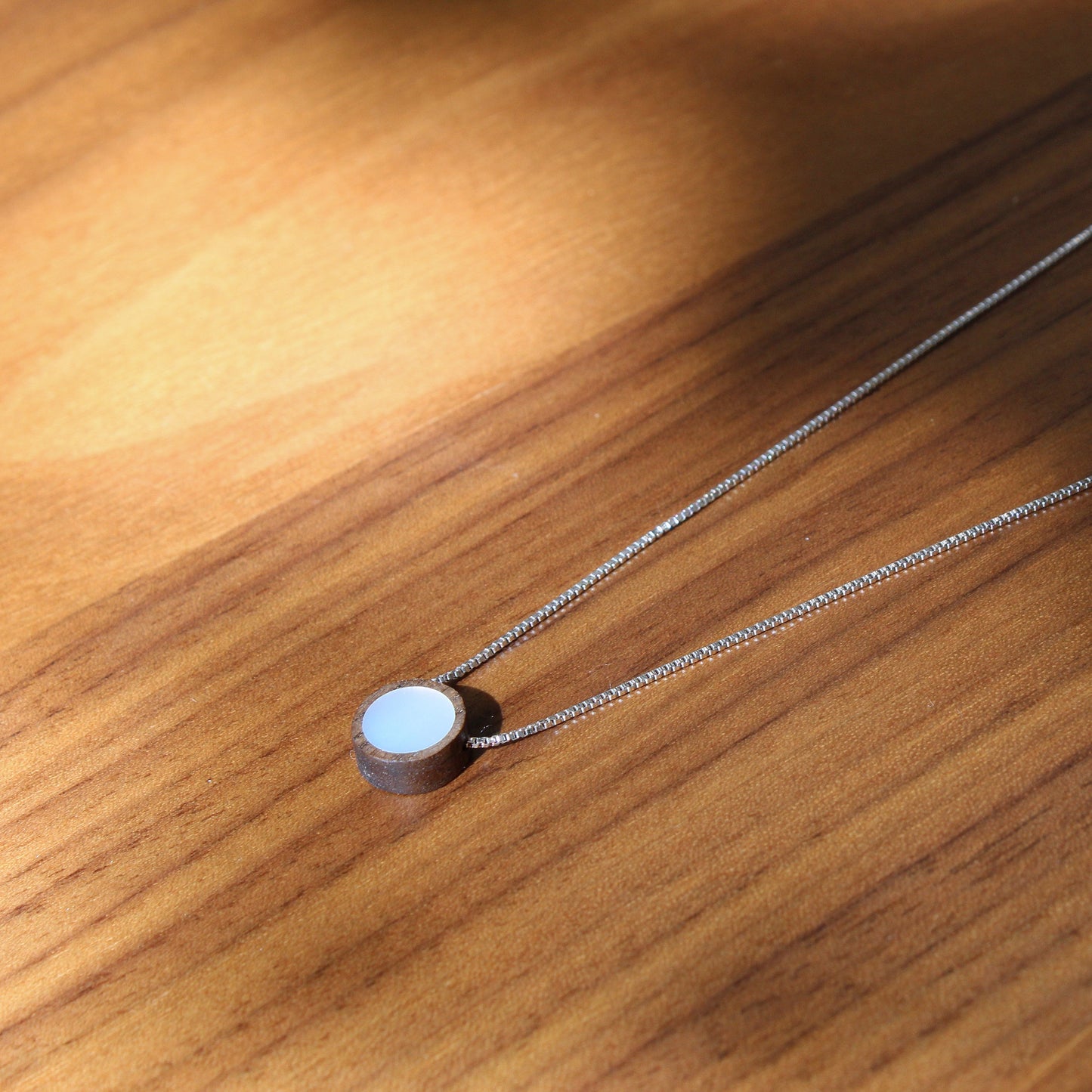 Necklace with a round pendant on a wooden surface