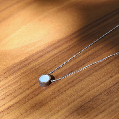 Necklace with a round pendant on a wooden surface