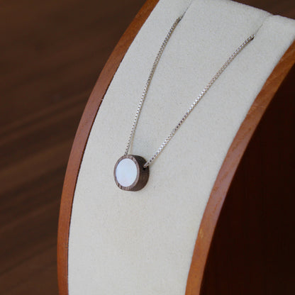 Necklace with a pendant on a wooden stand against a wooden background