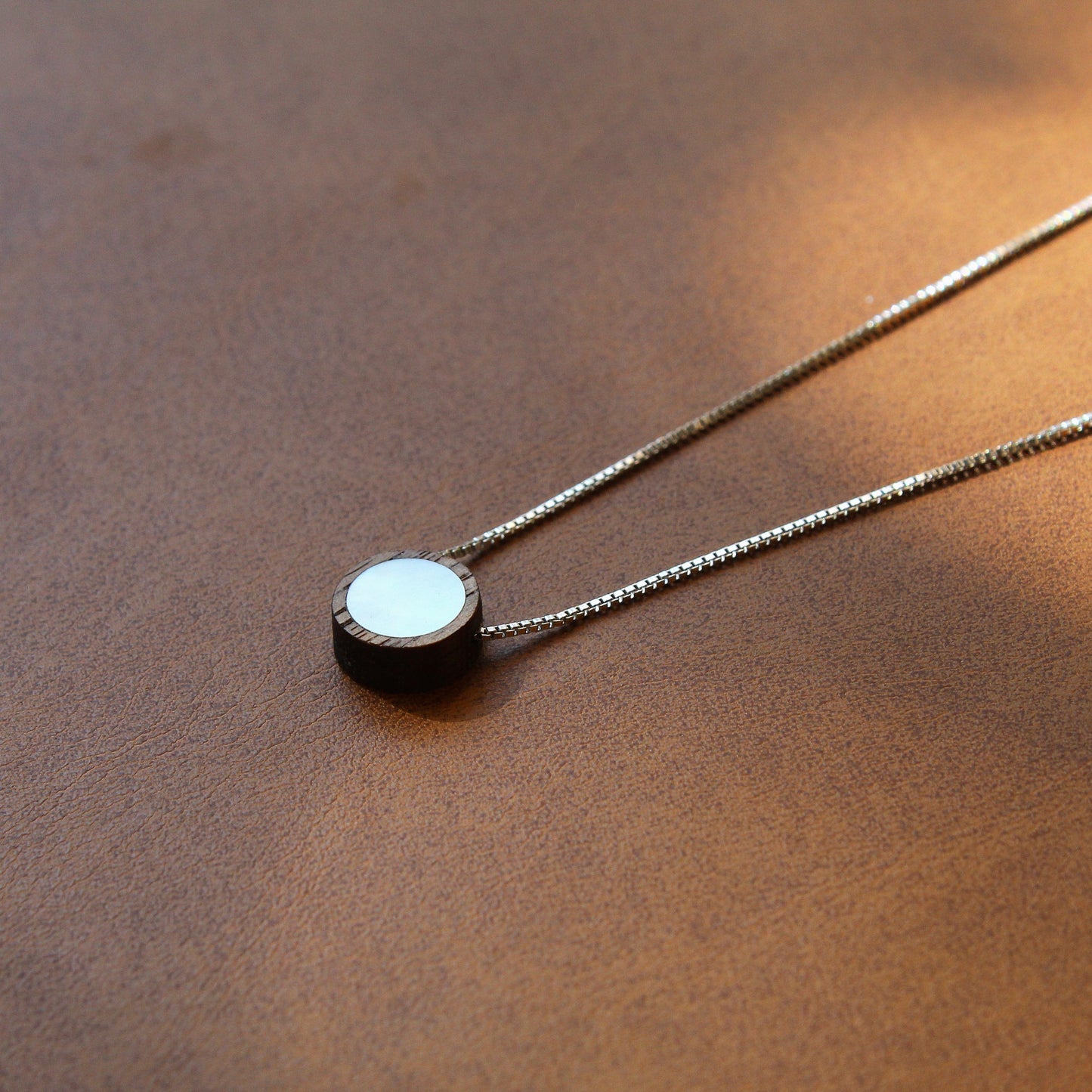 Necklace with a round pendant on a brown surface