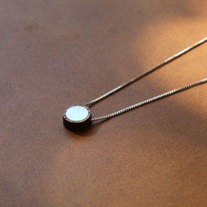 Necklace with a round pendant on a brown surface