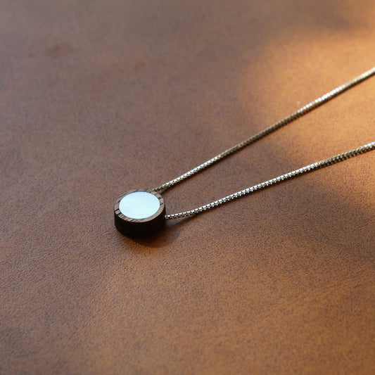 Necklace with a round pendant on a brown surface